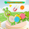 A green magnetic caterpillar puzzle toy with colorful shapes and pieces on a wooden base.