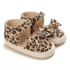 Pair of leopard print baby first walkers with soft rubber soles and fabric straps.