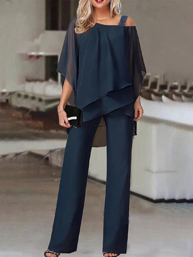 En kvinne modellerer et marineblått off-shoulder topp og vidbukse-sett.