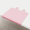 Pink silicone feeding placemat with a decorative teething edge shown on a light surface.