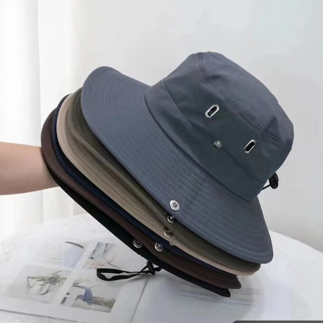A gray men's UV protection wide brim bucket hat is shown resting on a white surface.