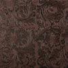 Close-up of dark brown vintage floral textured faux leather fabric with intricate embossing.