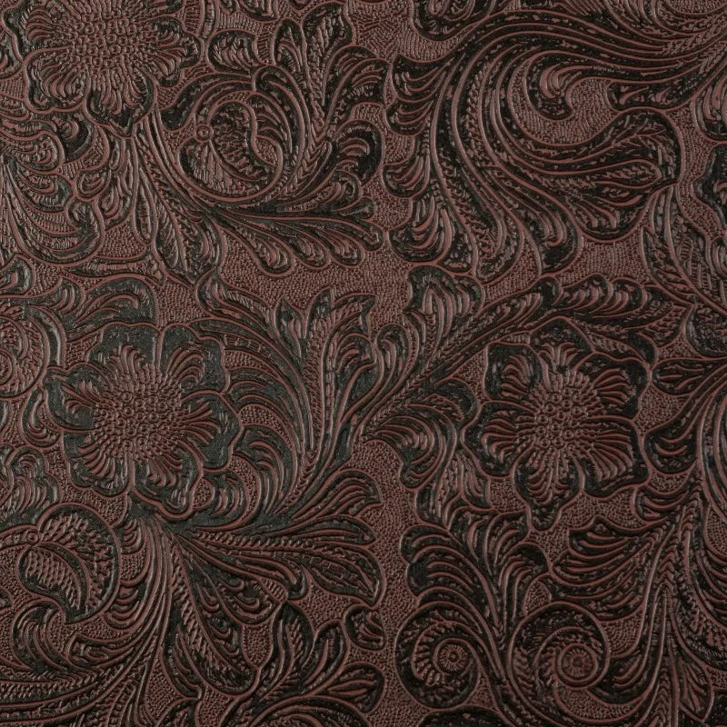 Close-up of dark brown vintage floral textured faux leather fabric with intricate embossing.