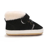 Black baby winter snow boots with a fluffy cream-colored shearling lining and white sole.