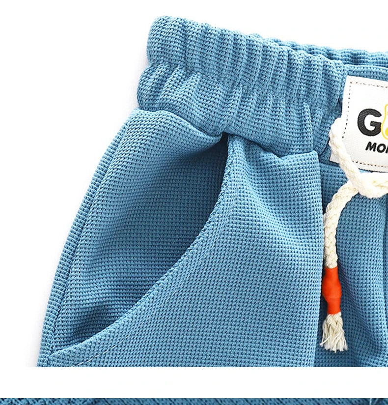 Light blue kids beach shorts with an elastic waist and a white tag