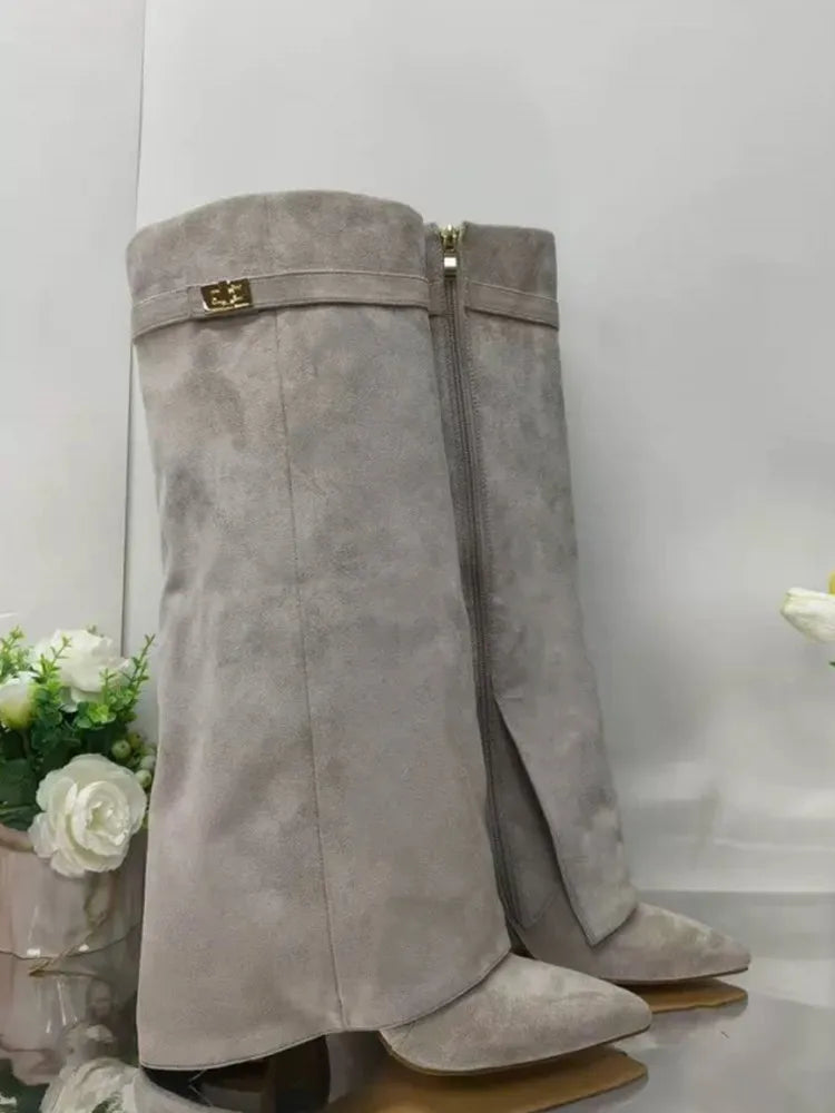 A pair of taupe suede knee-high boots with chunky heels and a gold metal buckle.
