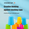 A collection of colorful plastic cups in various shades of blue, yellow, green, and pink, arranged for a stacking game.