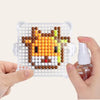 A hand holds a clear plastic tray filled with 300 colorful water beads in the shape of a dog face.