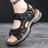 A close-up of a black men's genuine leather air cushion sandal with a tan sole and strap details.