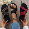 A pair of women's breathable mesh flat sandals in black and maroon are shown being held by a person.