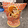 An orange and gray fabric cat tunnel toy with a yellow entrance, featuring a kitten looking out.