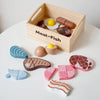 A wooden pretend play food cutting set featuring various shapes and colors of food items in a wooden box.