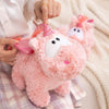 A pink unicorn plush pillow is being held by a person, showing its soft texture and details.