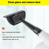 A black handheld steam cleaner with a brush attachment is shown cleaning a glass surface.
