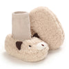 A pair of light beige, fuzzy cartoon animal baby booties with soft soles and a knitted cuff.
