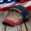 En mörkblå basebollkeps med broderad amerikansk flagga och text som firar 250-årsjubileet, vilande på trä