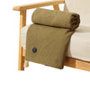 A textured olive green knitted shawl or blanket draped over a light-colored sofa.