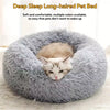 A fluffy gray pet bed with a donut shape, featuring a small tabby kitten nestled inside.