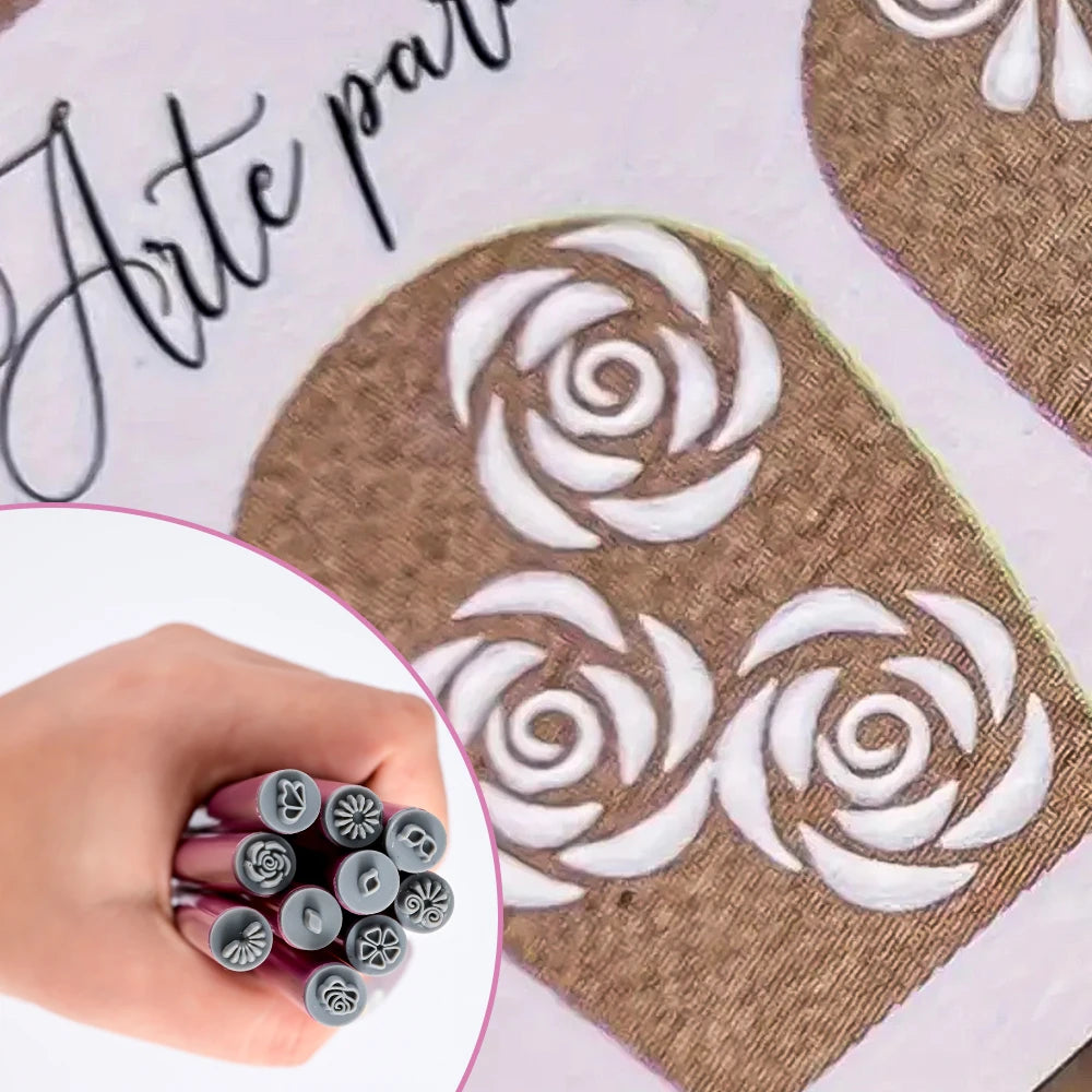 En hånd holder et sett med neglekunst-stemplingsverktøy med blomstermønstre på en beige bakgrunn.