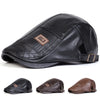 Black men's retro faux leather newsboy cap with a brown square emblem shown from the side.