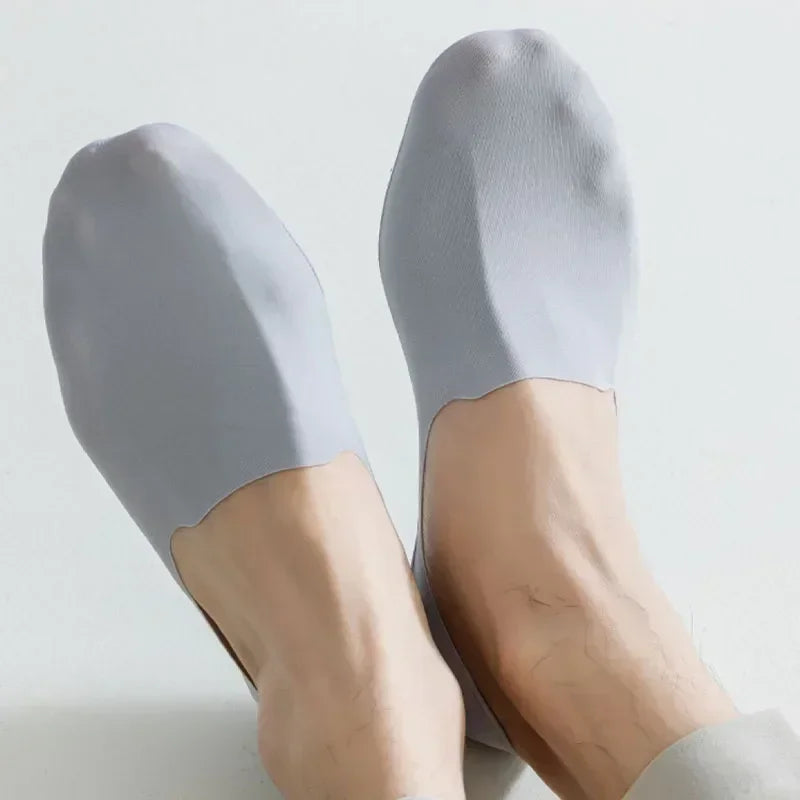 A pair of light gray men's no-show socks with silicone grip shown on a foot.