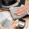 A hand is using a scratch-free microfiber cleaning cloth to wipe a surface, demonstrating its use for kitchen and home cleani
