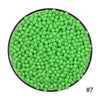 A circular arrangement of numerous bright green water beads.