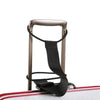 A close-up view of adjustable elastic luggage straps with a brown frame and black strap, resting on a red and white surface.