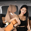 A woman is shown using a car armrest cushion with dual cup holders inside a car.