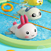 Cute duck and penguin bath toys being used in a blue water pool.