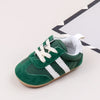 A pair of green and white baby first walker shoes with a TPR sole shown against a white background.
