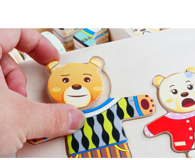 A hand holds a wooden puzzle of a bear dressed in a striped shirt, used for Montessori dress-up play.
