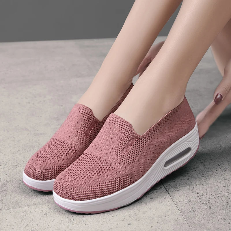 Un par de zapatos de caminar para mujer, color rosa empolvado, con cojín de aire y plataforma gruesa blanca.
