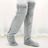 Graue, flauschige, kniehohe Socken mit Fleece-Futter auf einem Fuß gezeigt.