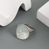 Silver ring featuring a large, iridescent pearl set in a polished metal band.