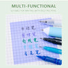 A collection of various colored pens and a sheet of graph paper are displayed on a light green background.
