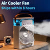 A white personal air cooler fan device is shown on a wooden surface with a soft light emitting from the unit.