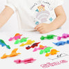 A set of colorful dinosaur finger catapult toys for kids displayed on a white surface.