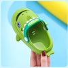 A hand holds a bright green kids shark clog sandal with a blue eye and a green strap.