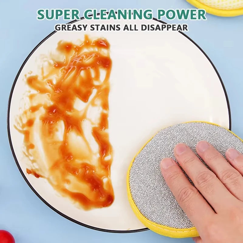 A hand is using a yellow scouring pad to clean greasy stains from food on a white plate.