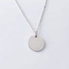 Collier pendentif rond argenté avec chaîne et médaillon lisse et circulaire.