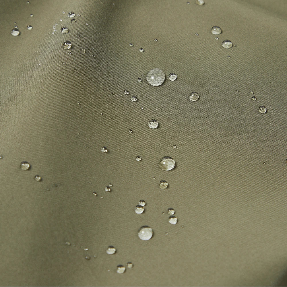 Close-up of a tan fleece fabric with water droplets on it.