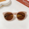 A pair of light pink sunglasses with brown lenses and a durable frame resting on a white surface.