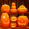 A collection of glowing orange carved pumpkin lanterns displayed on wooden shelves.