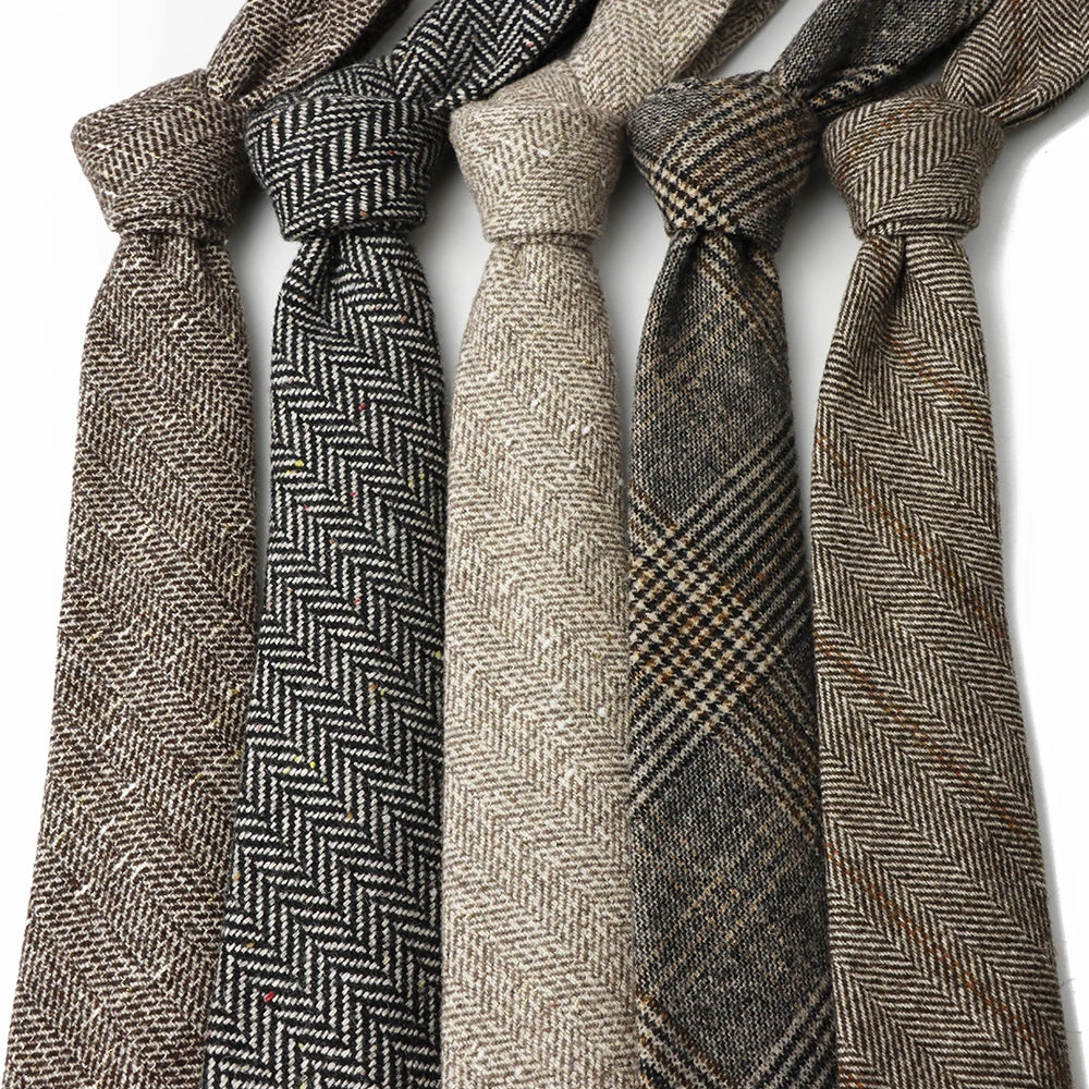 En samling klassiske ullherringbone-slips i ulike jordfarger og mønstre.