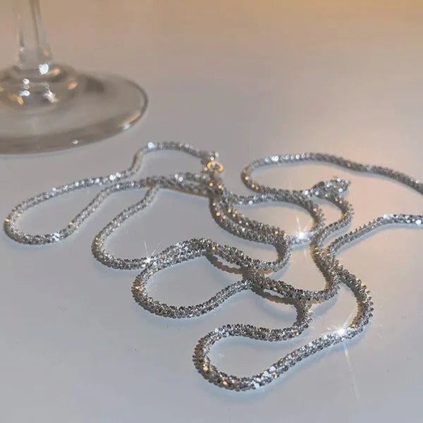 قلادة choker متلألئة من الكريستالات الشفافة معروضة على سطح أبيض.