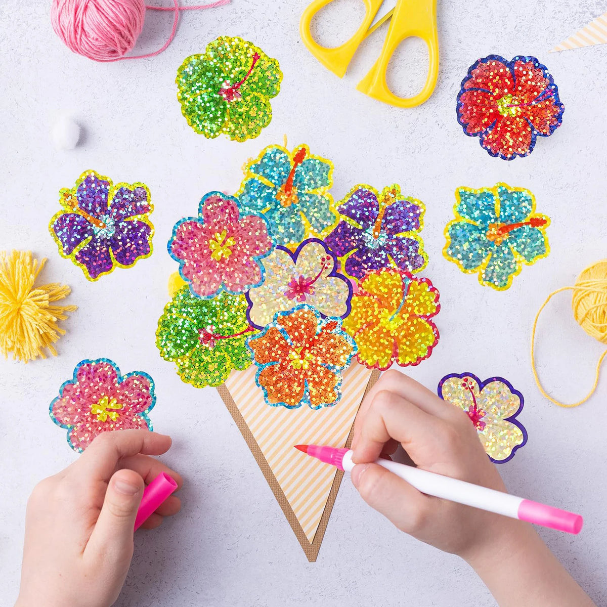 Hands are applying glitter flower round stickers to a piece of cardstock for crafting or decoration.