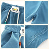 Blue kids beach shorts with elastic waist featuring a grid texture and a white tag.