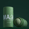 A tube of green tea cleansing stick mask with a green product visible on the side.