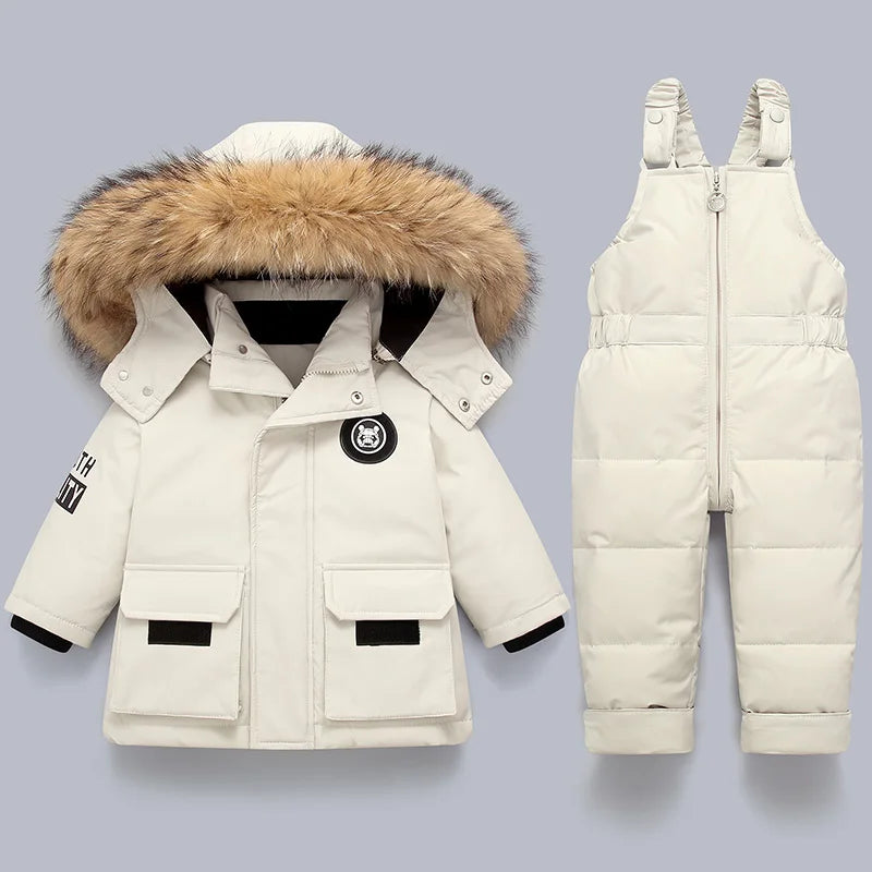 A cream-colored kids winter down coat with a natural fur collar displayed on a light gray background.